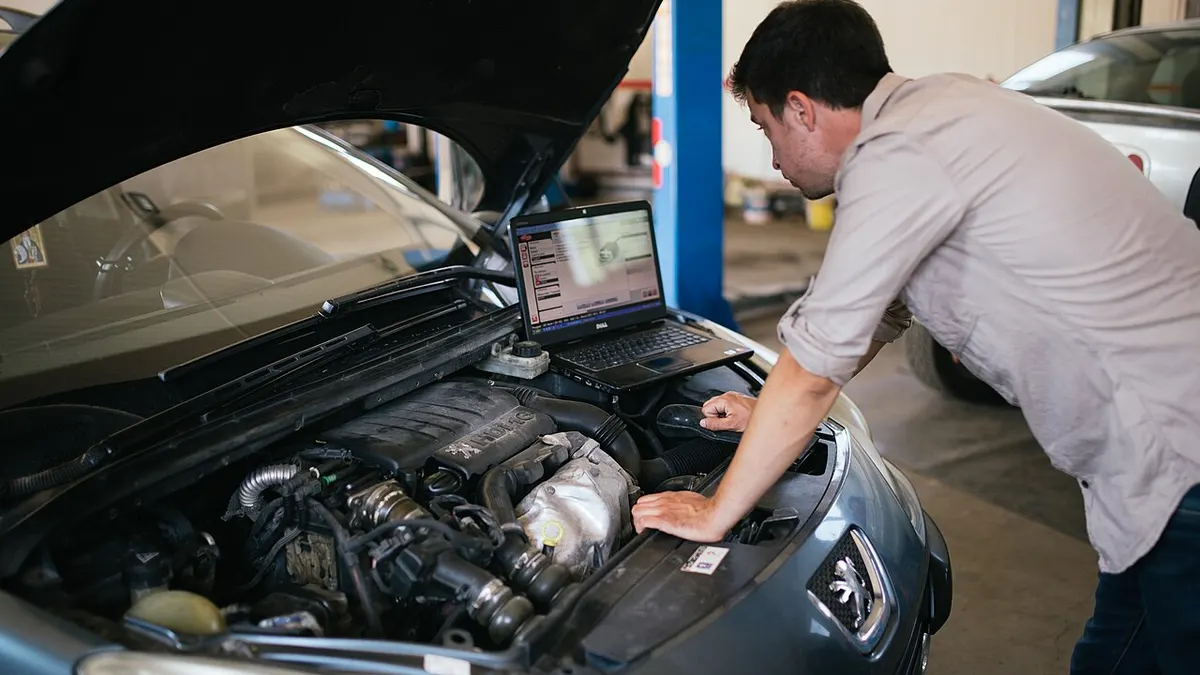 An automotive technician using tools during a repair